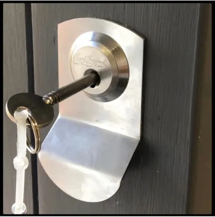 Bramah cylinder escutcheon and key on a timber door