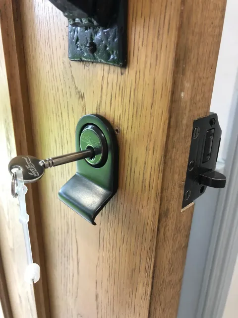 Joseph Bramah cylinder pull and key fitted to an oak front door in Amersham alongside a black rim deadlock