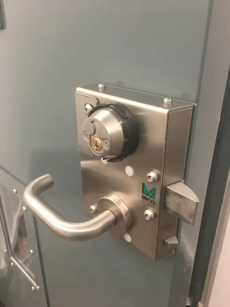 Stainless MICO lock case and lever handle fitted to a steel commercial door