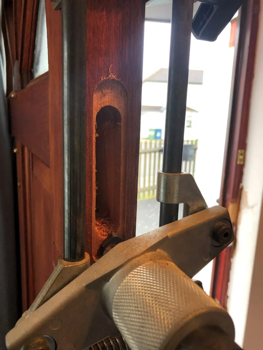 Open-in Security Services engineer chiselling a mortice lock pocket in a timber door