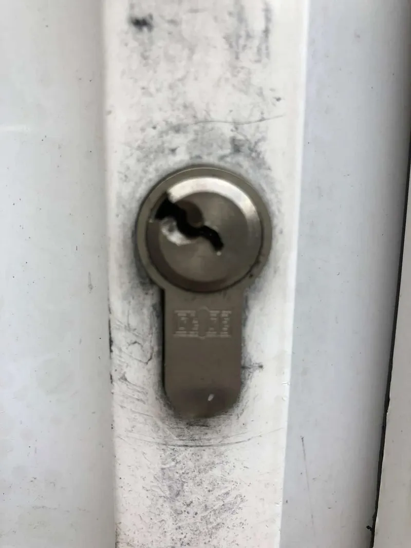 Pick in the keyway of a euro cylinder on a chrome-plated timber door