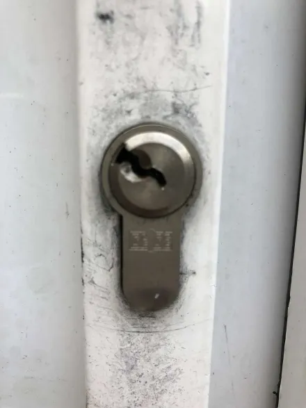 Pick in the keyway of a euro cylinder on a chrome-plated timber door