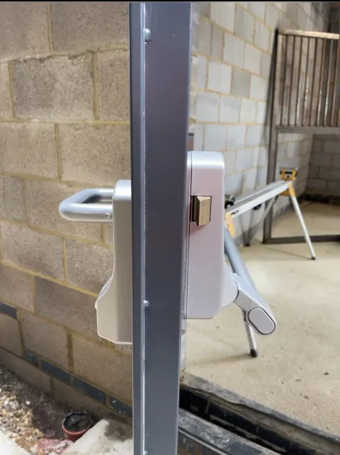 Panic push bar and outside access device fitted to a steel fire door in Iver