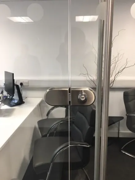 Clamp-on lock fitted to a frameless glass office partition door