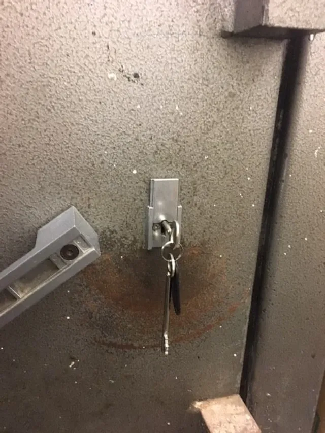 New keys hanging in the lock of a grey steel plant-room door
