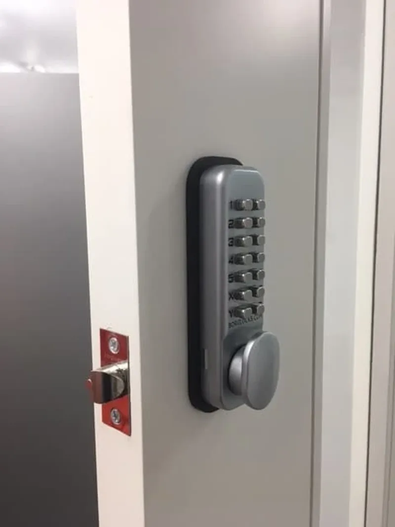 Push-button code lock fitted to a white office door