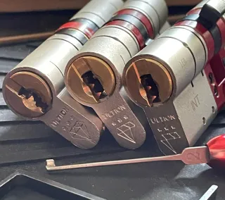 Three boxed Ultion anti-snap euro cylinders with keys laid out before installation