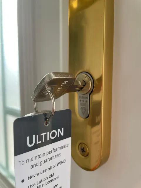 Ultion three-star anti-snap cylinder in a brass handle plate fitted in Pinner, key and care tag attached