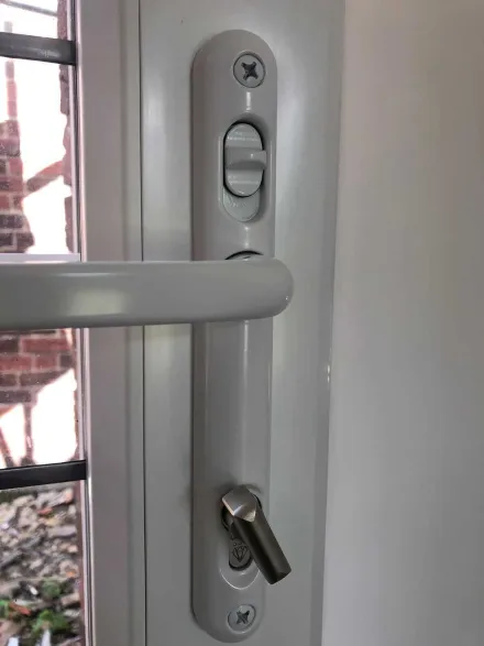 Inside face of a white uPVC handle with snib and key in the new cylinder