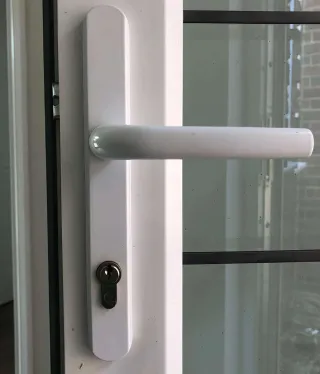 Multipoint locking strip and handle on the edge of a white uPVC door